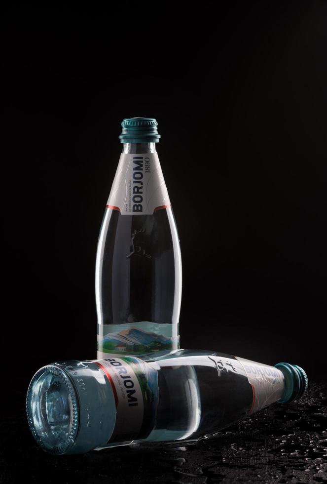 KRASNOYARSK, RUSSIA - OCTOBER 21, 2022 Two bottles of Borjomi natural mineral water on a black background. photo