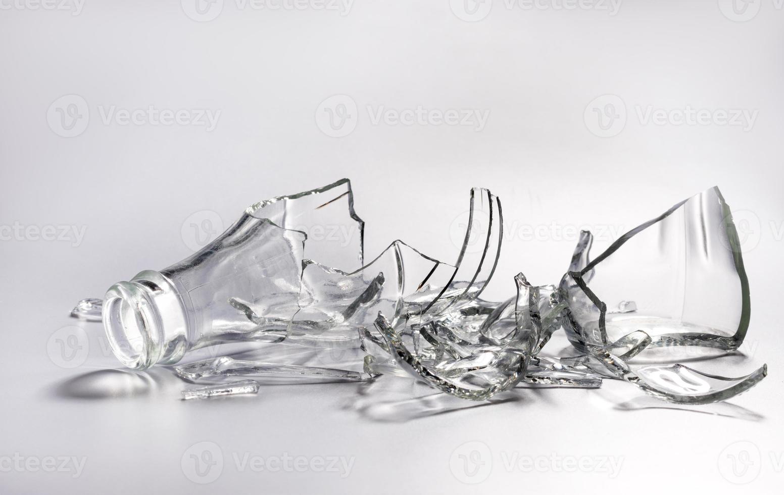 Broken glass bottle. Sharp shards of clear glass. photo