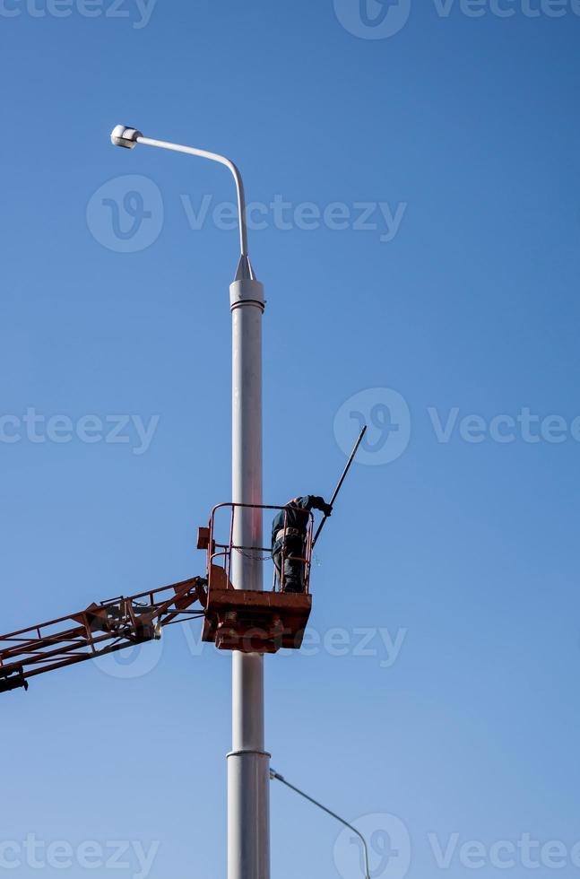 worker is busy painting a pole photo