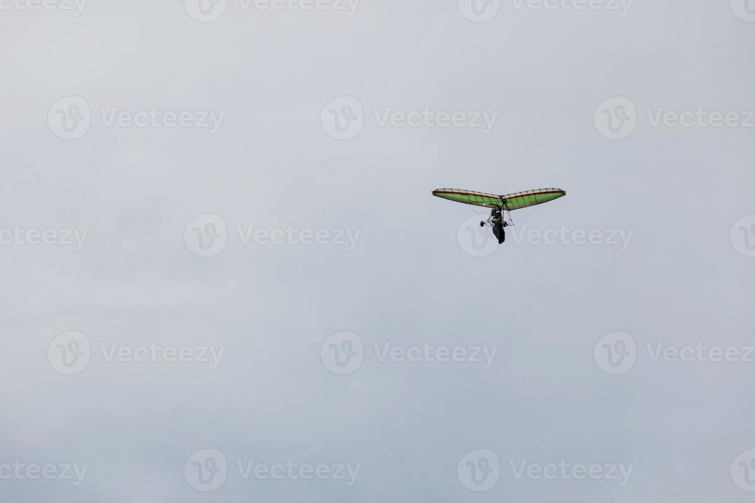 Powered hang glider flying in blue sky. photo