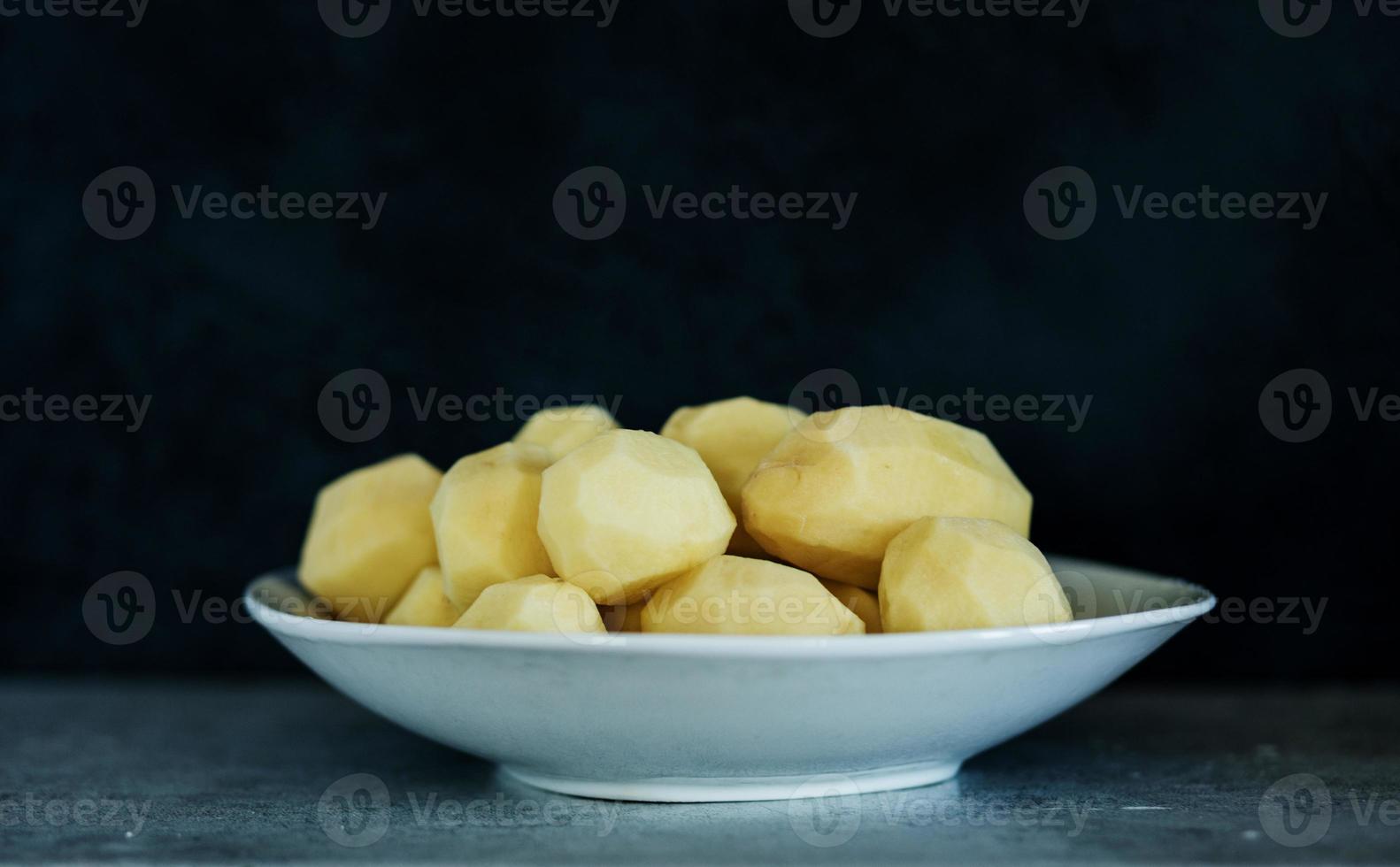 Peeled potatoes in plate photo