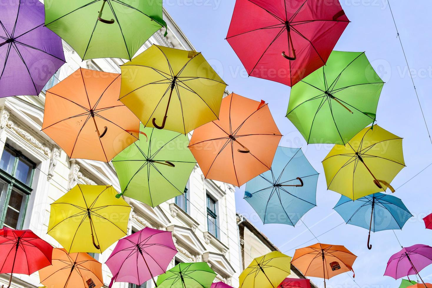 paraguas de colores colgado en las calles de la ciudad foto