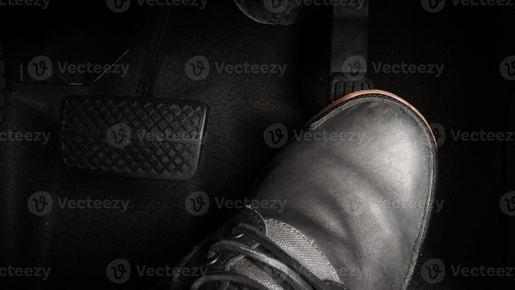 Close up foot press or push foot break and accelerate pedal of a car to drive ahead. photo