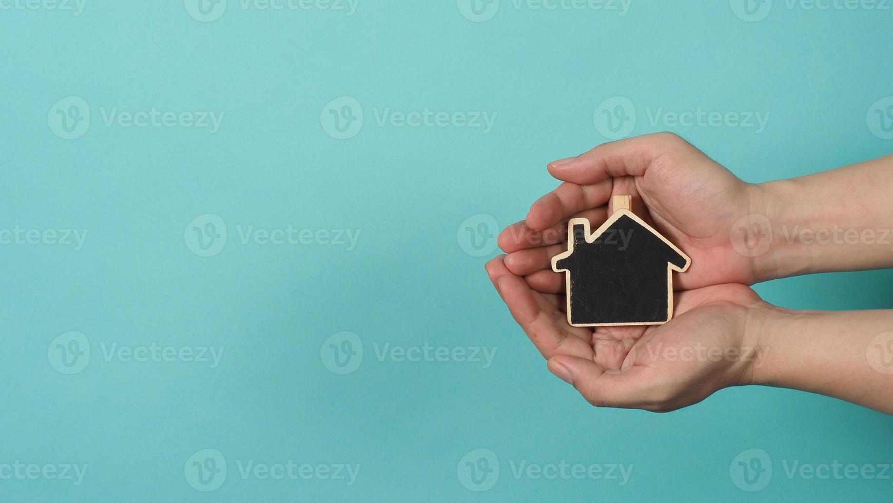 Small wood house in hands represent concepts such as home care family love photo