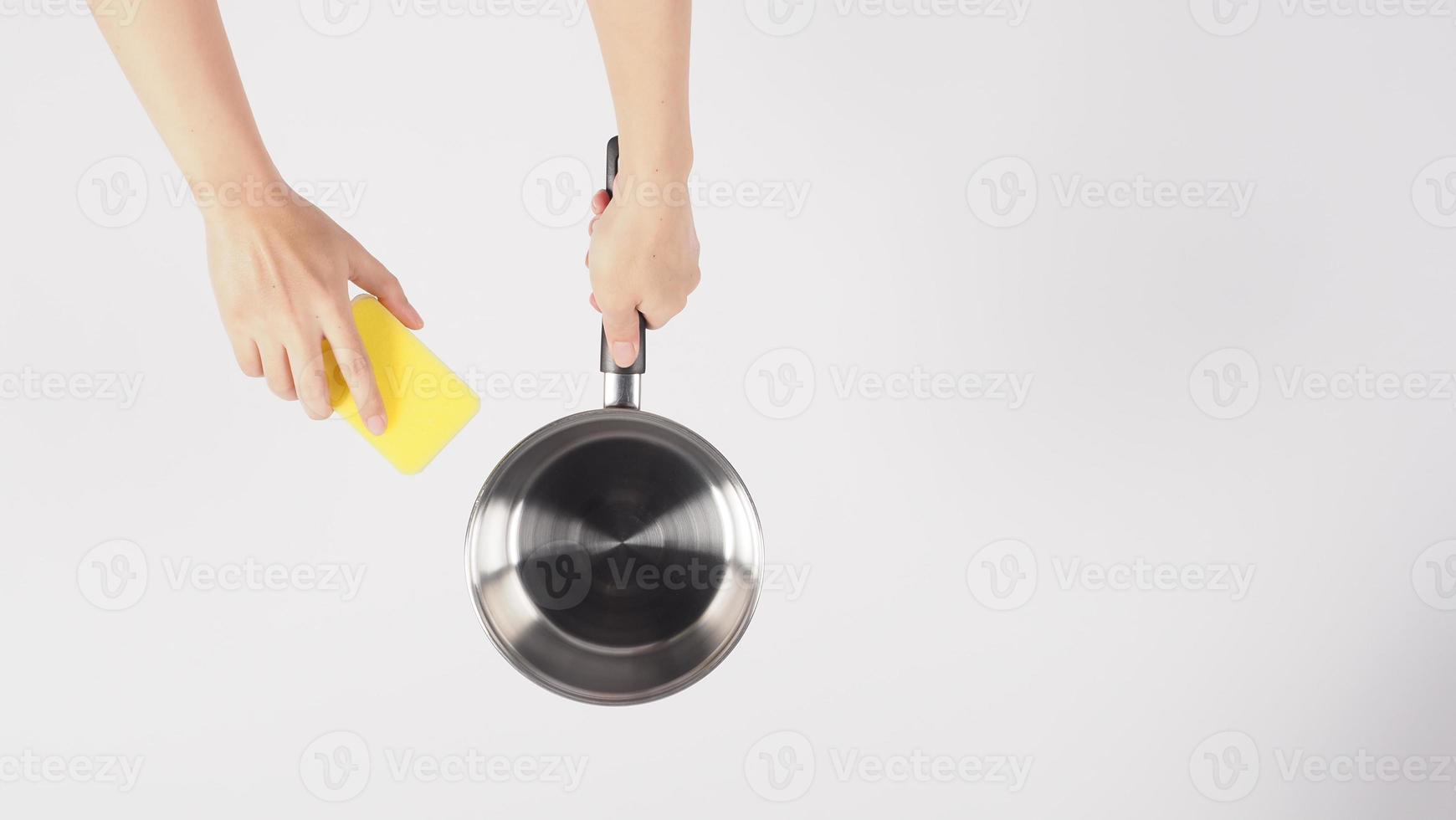 Pot cleaning Man hand on white background cleaning the non stick pot photo