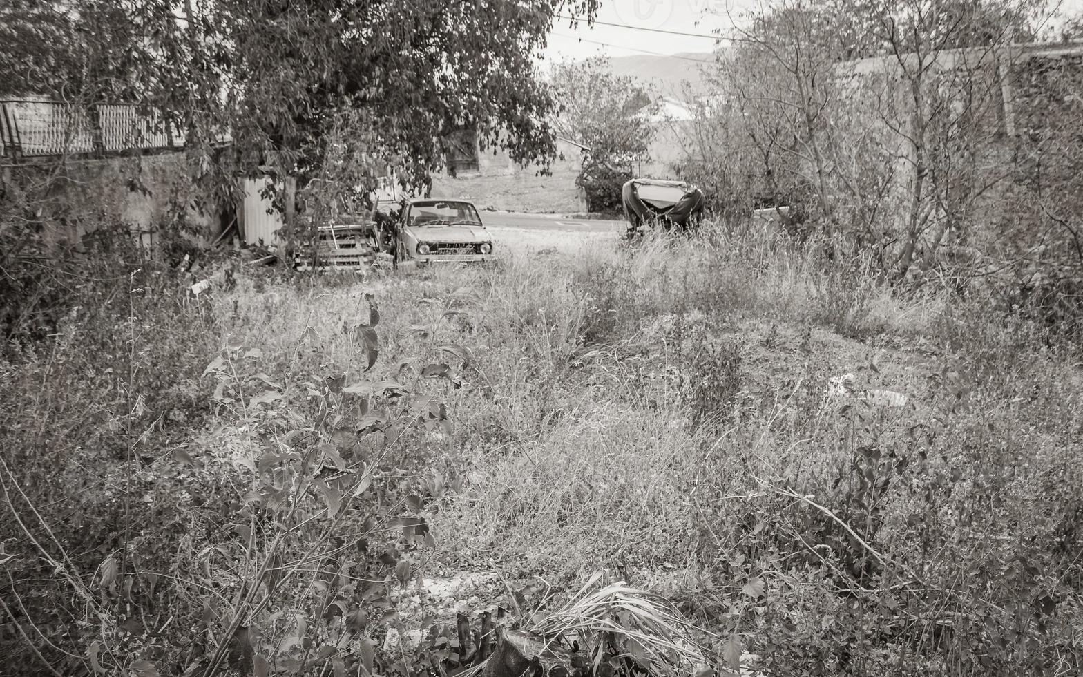 Old broken small car parked in natural chaotic garden Croatia. photo