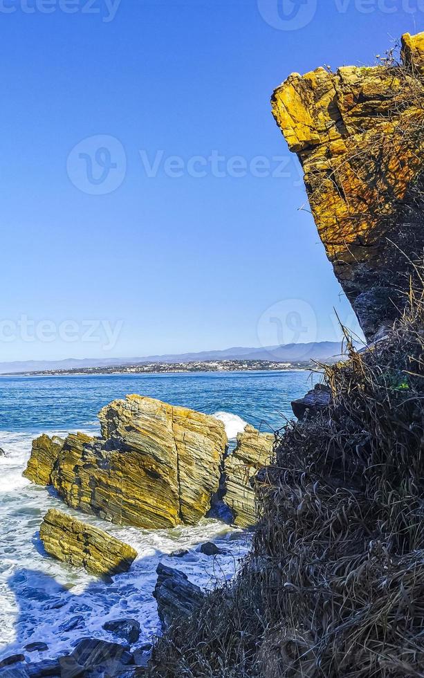 hermosas rocas acantilados olas surfistas en la playa puerto escondido mexico. foto