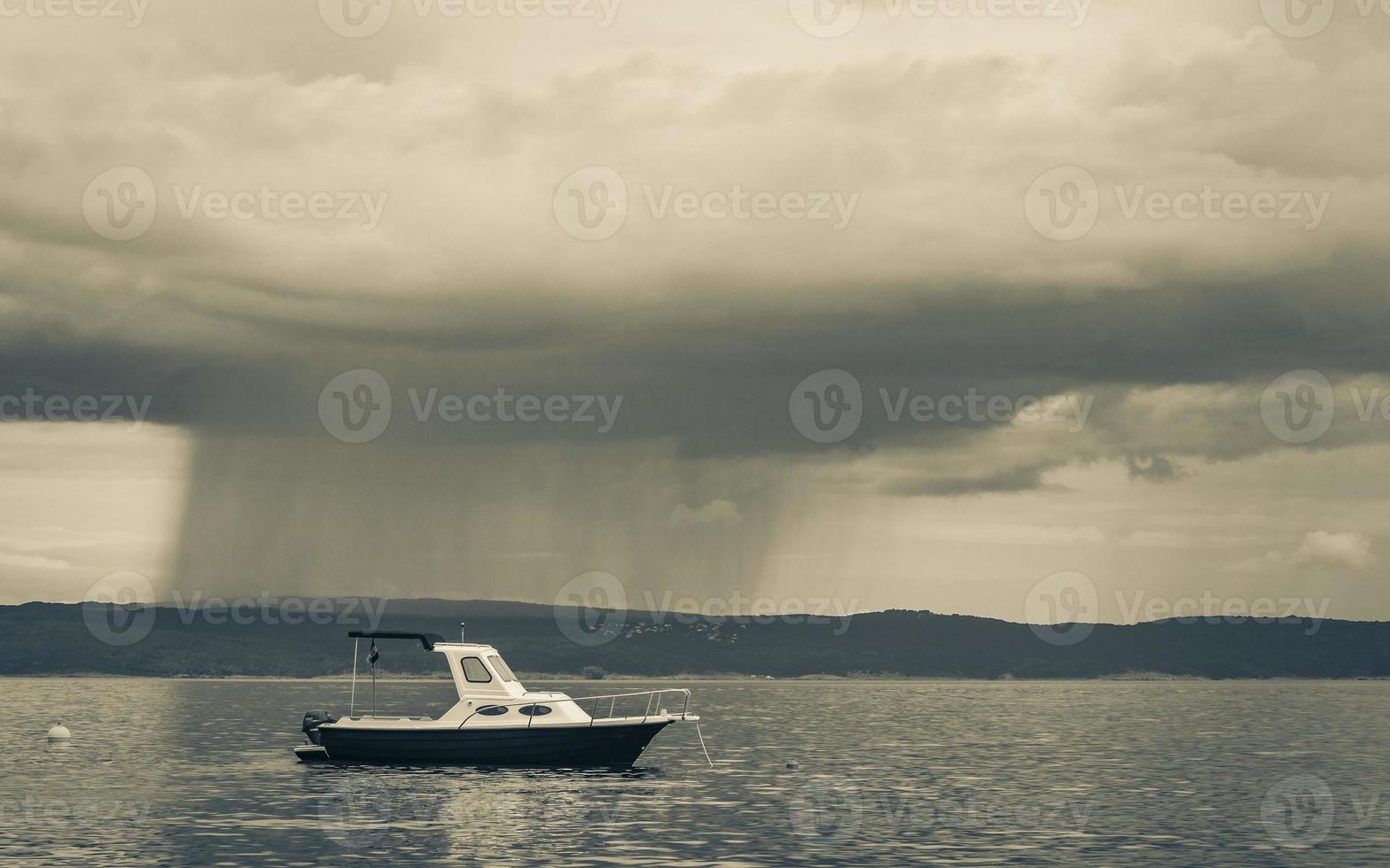 enormes nubes de lluvia duchas detrás de un barco novi vinodolski croacia. foto