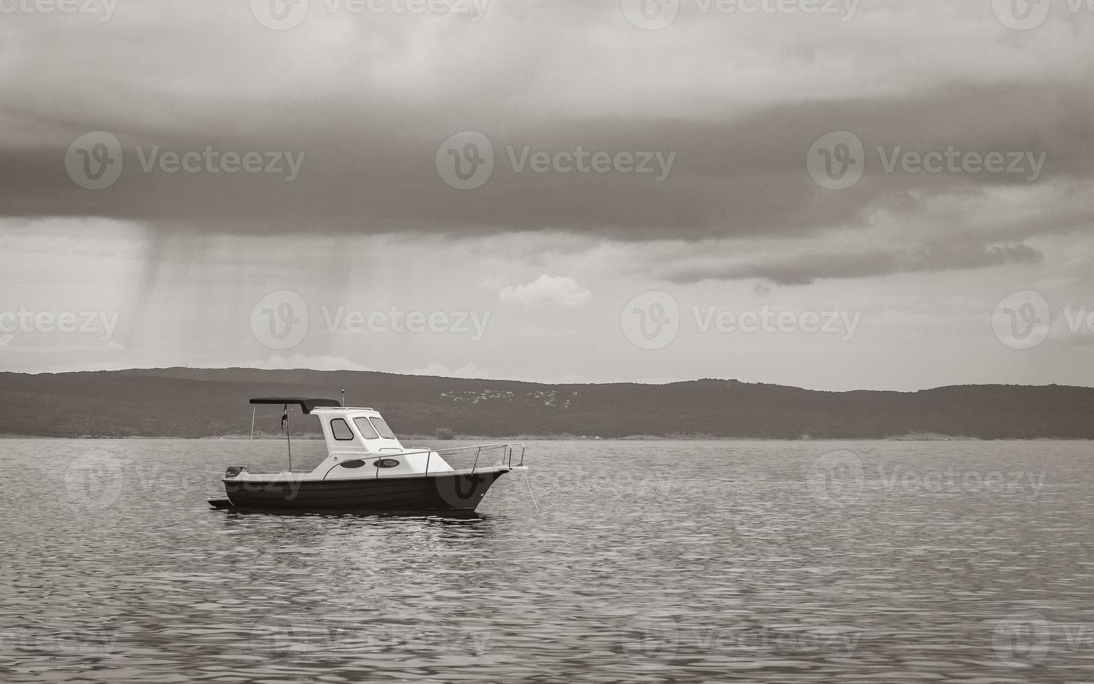 enormes nubes de lluvia duchas detrás de un barco novi vinodolski croacia. foto