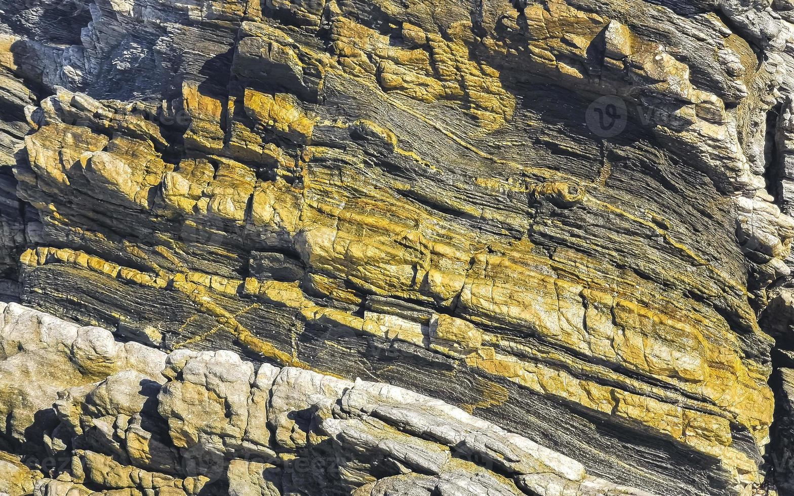 Beautiful rock cliff stone boulder texture pattern beach in Mexico. photo
