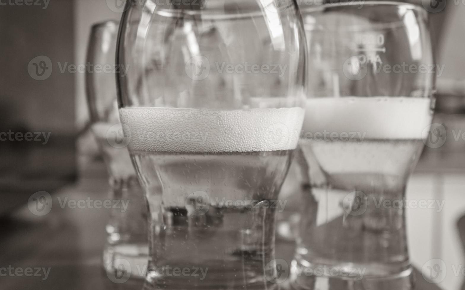 Three glasses with gold-colored pils beer half full. photo