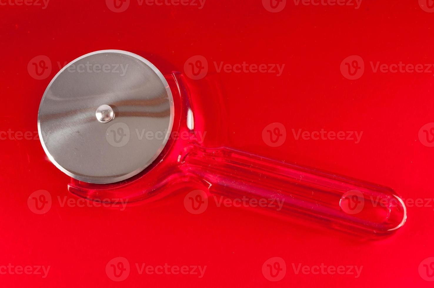 Pizza cutter on red photo