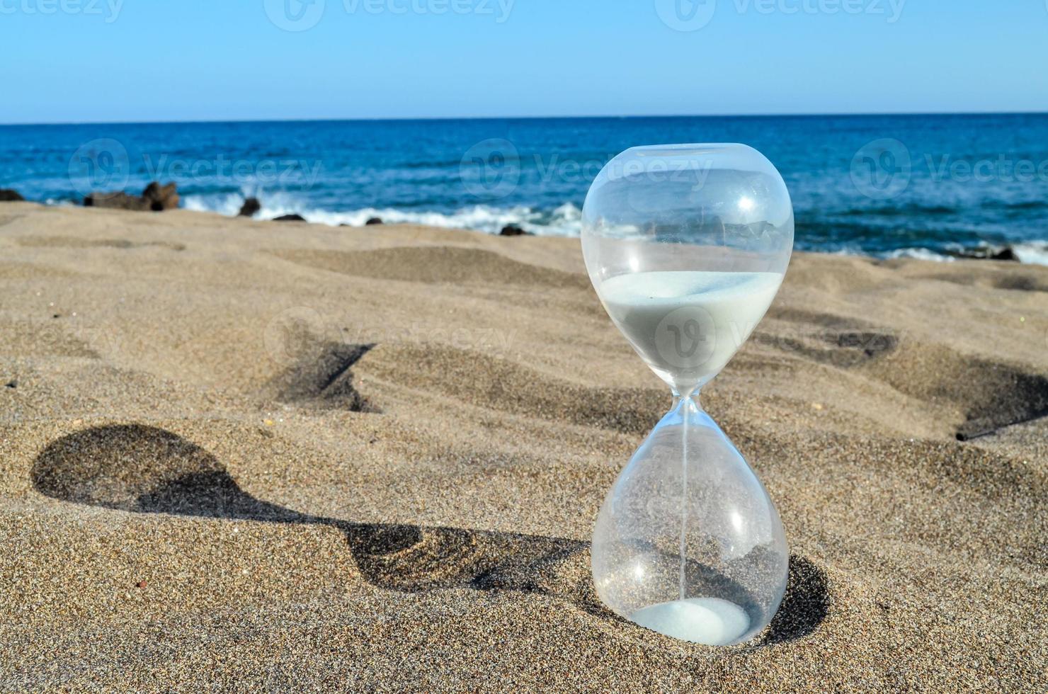 Hourglass on the sand beach photo