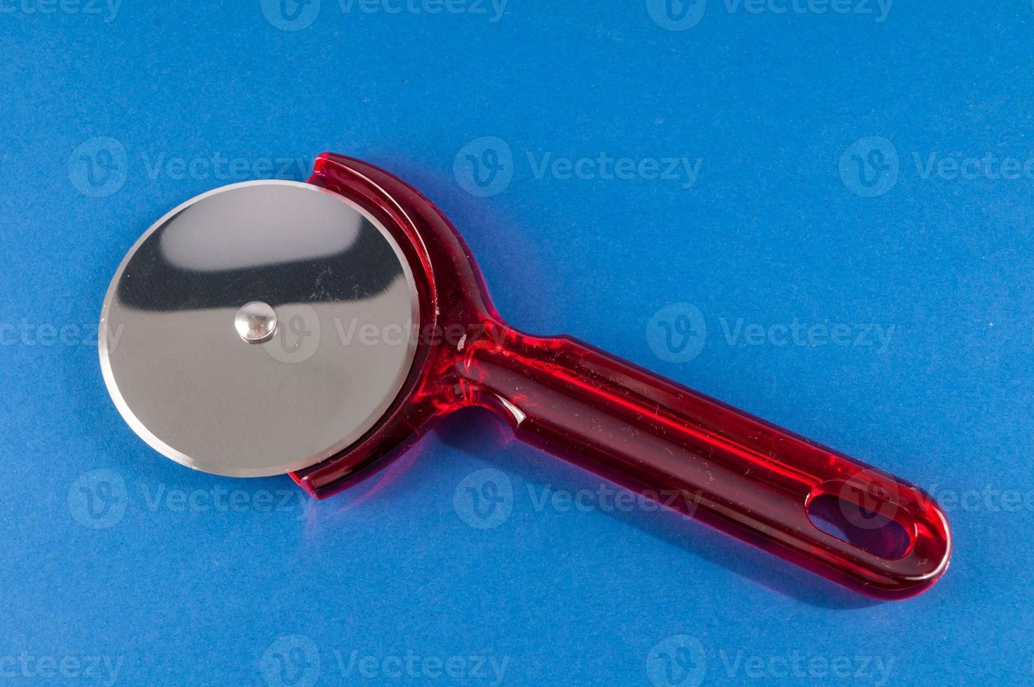 Pizza cutter on blue background photo