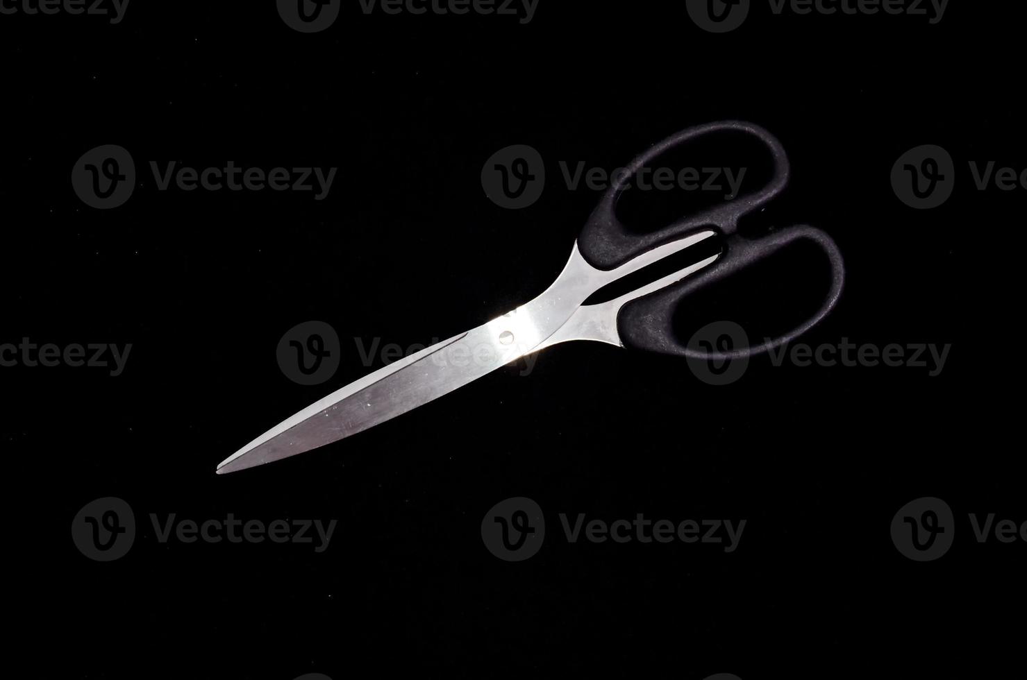Scissors on black background photo