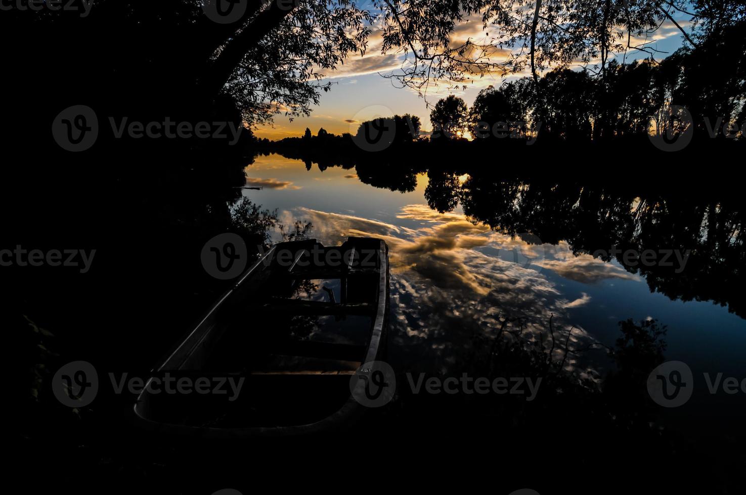 barco en el río al atardecer foto