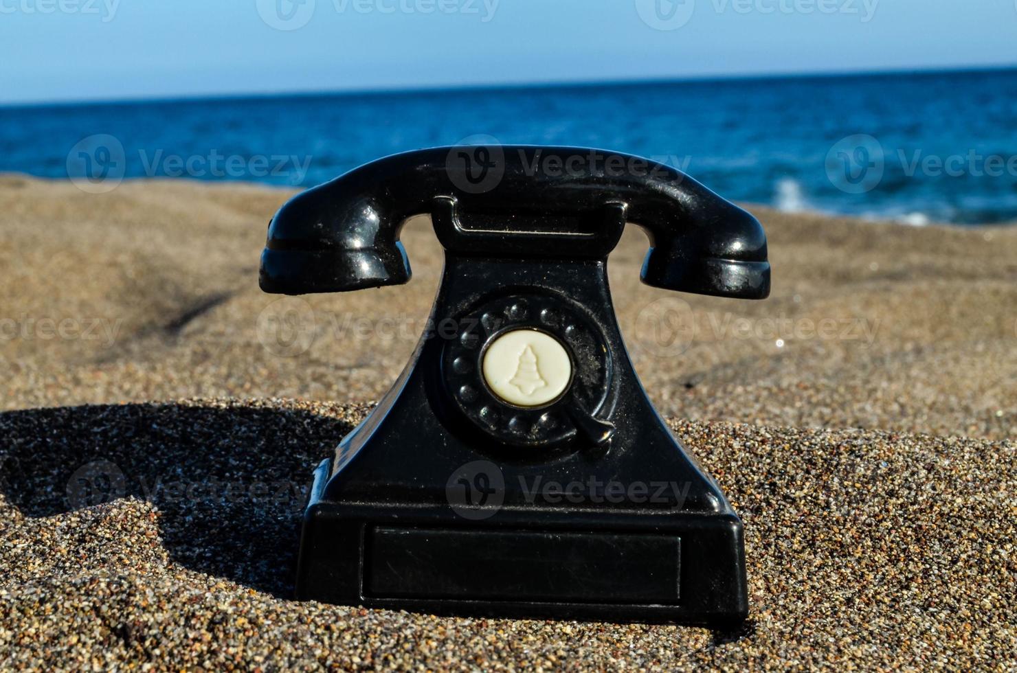 Old telephone on the beach photo