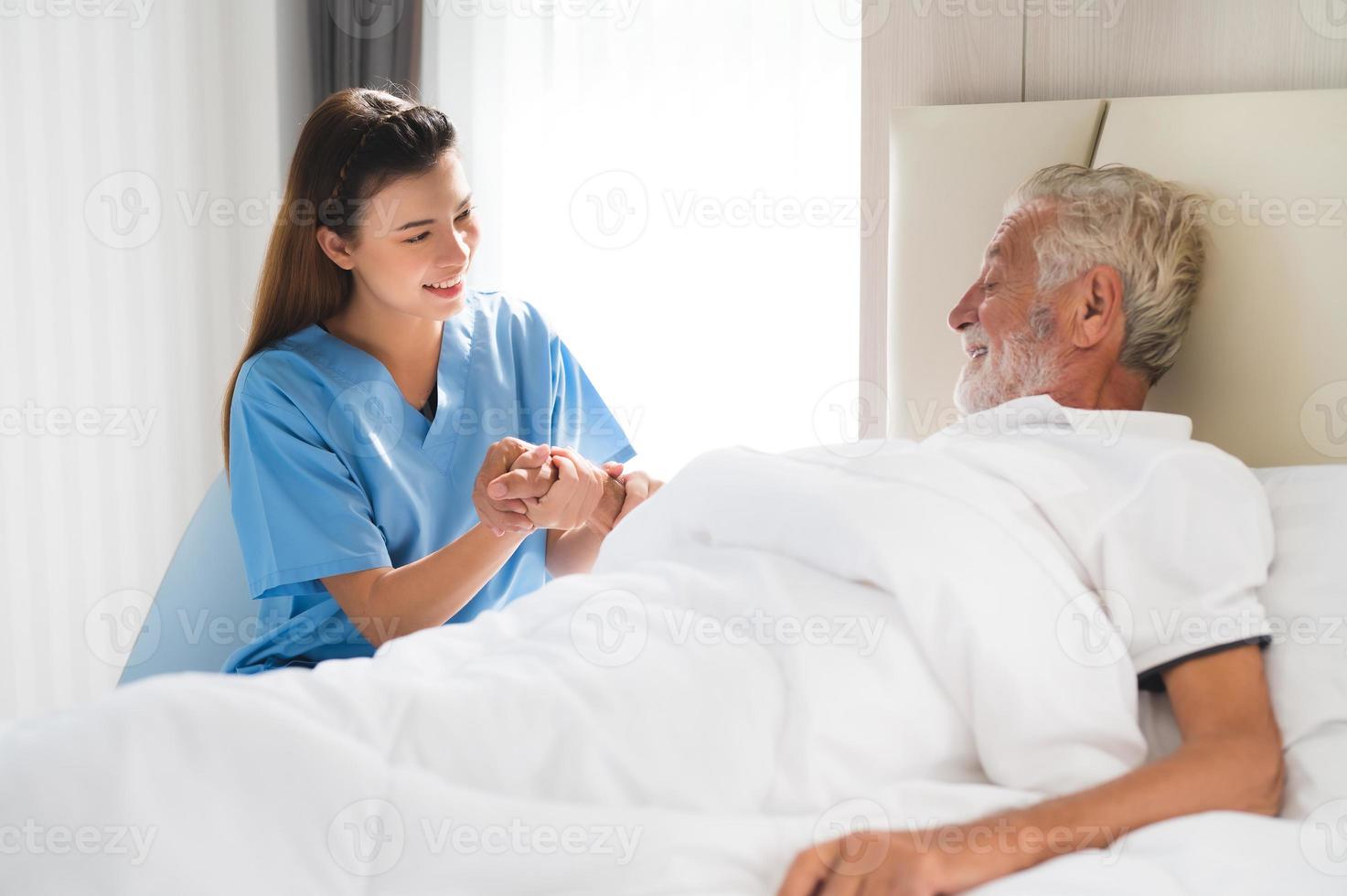 caregiver holding elderly man patient hand photo