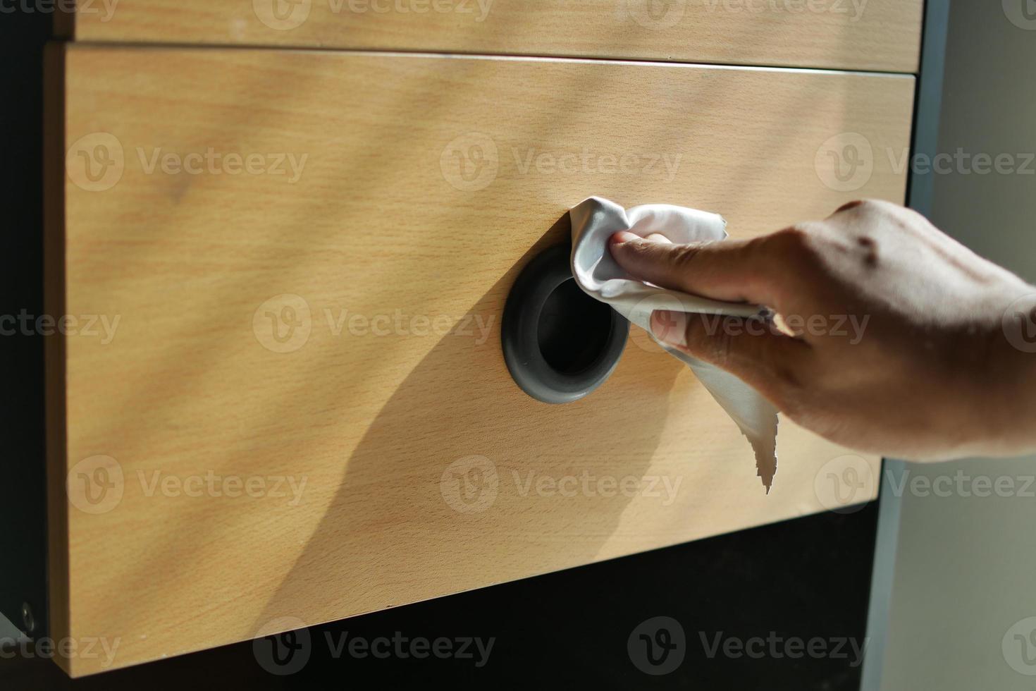 person hand cleaning drawer with a tissue photo