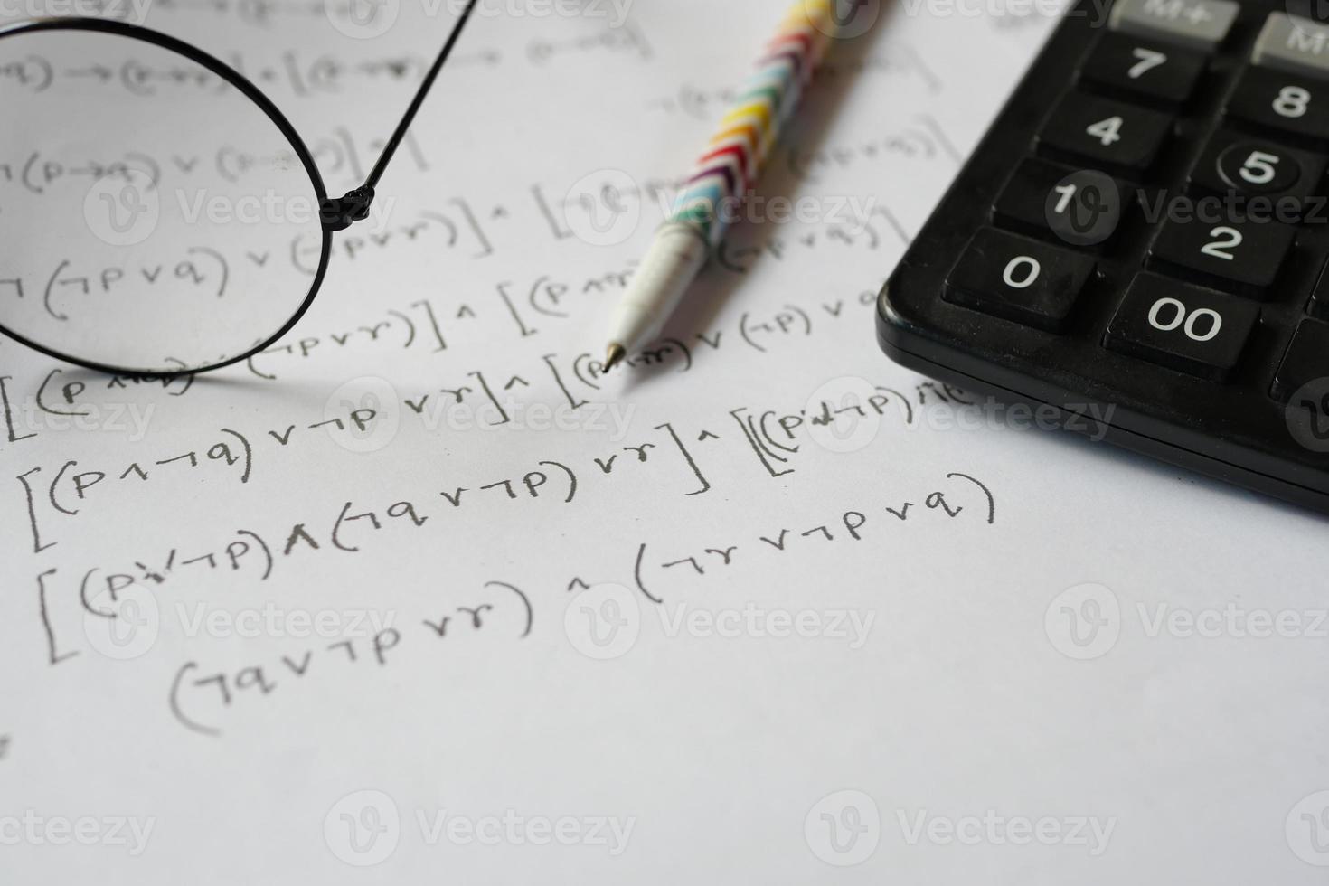 Hand writing algebra equations on a paper photo