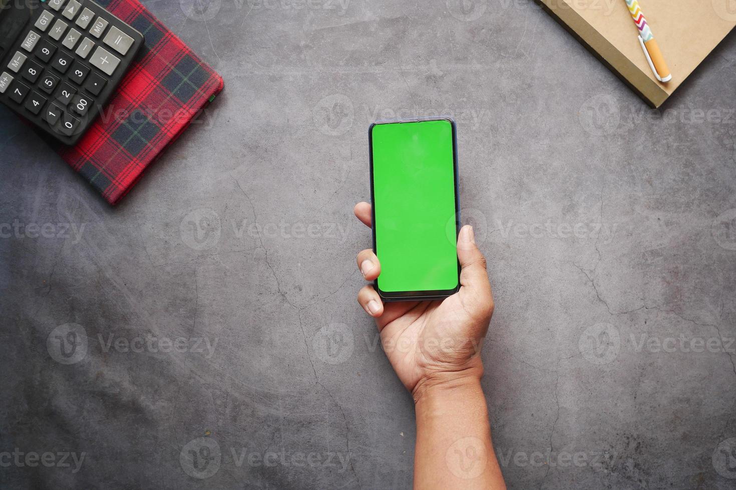 top view of man hand using smart phone on office desk photo