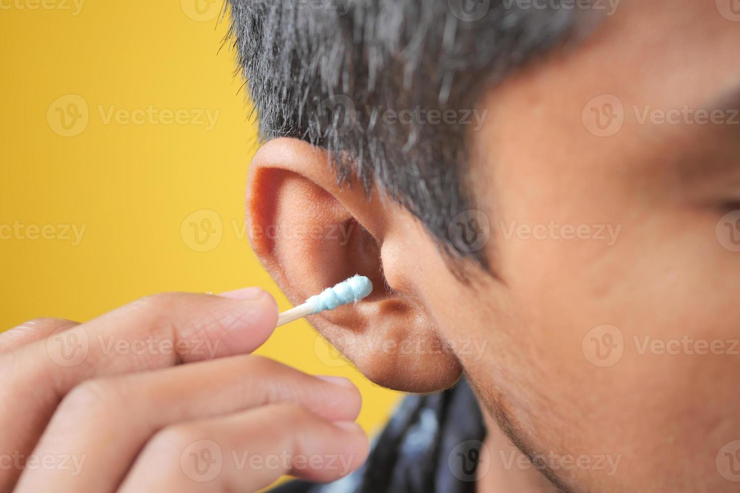 men using ear cotton bar close up photo