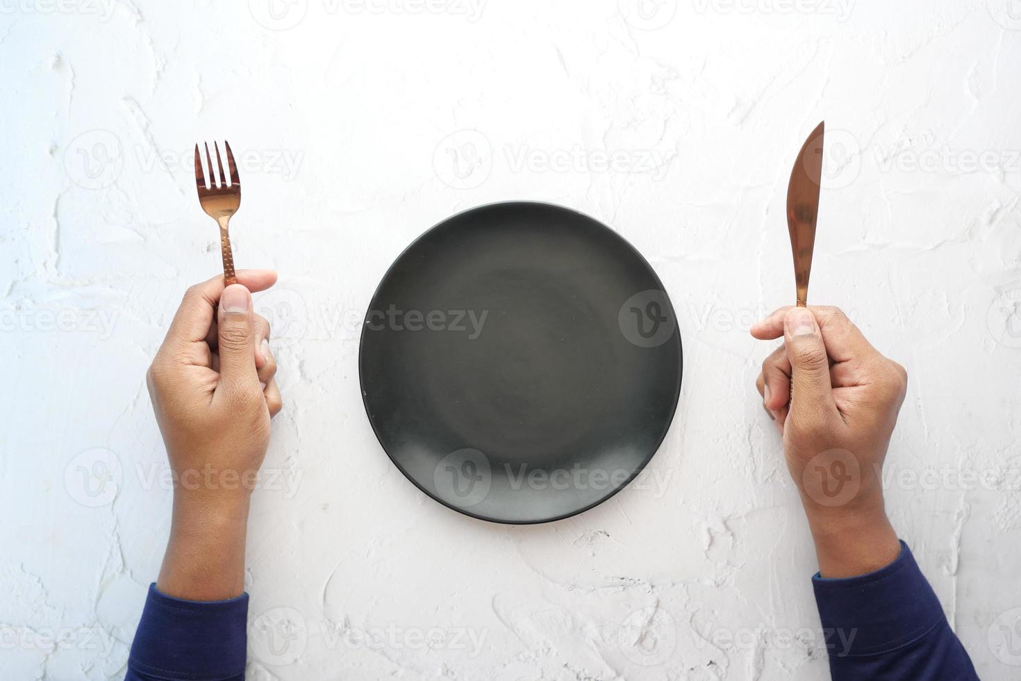 cutlery and empty plate on wooden background top down photo