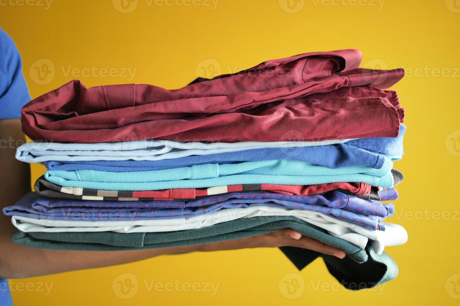 men holding stack of shirts photo