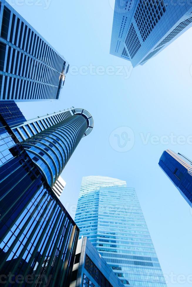 low angle view of singapore city buildings against blue sky photo