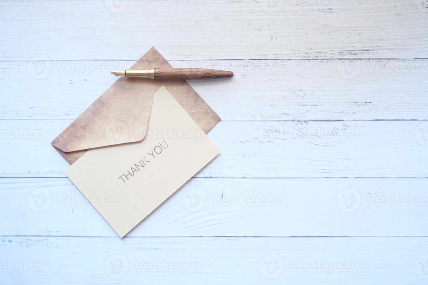 thank you message and envelope on wooden table photo