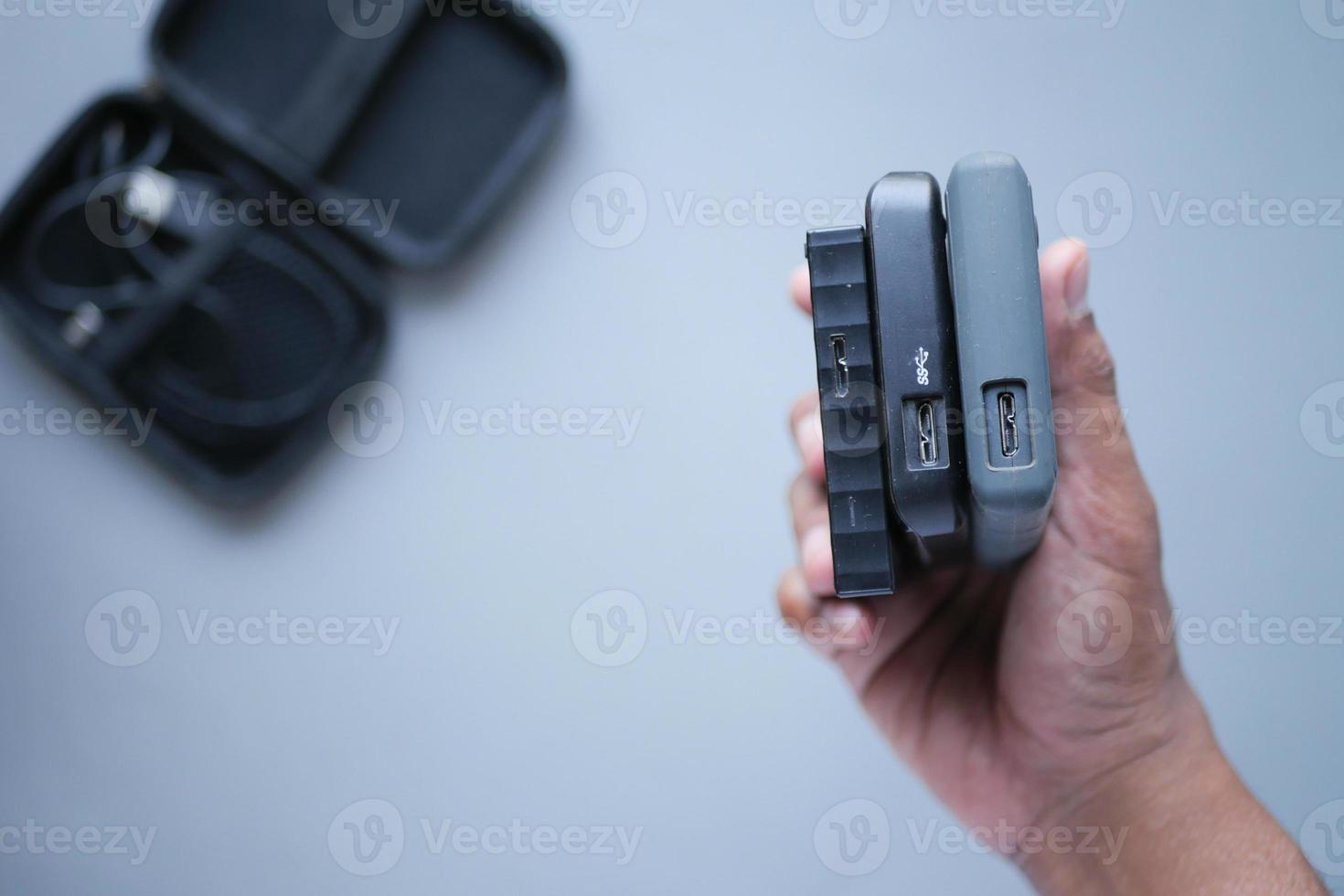 holding a stack of external hard drives photo