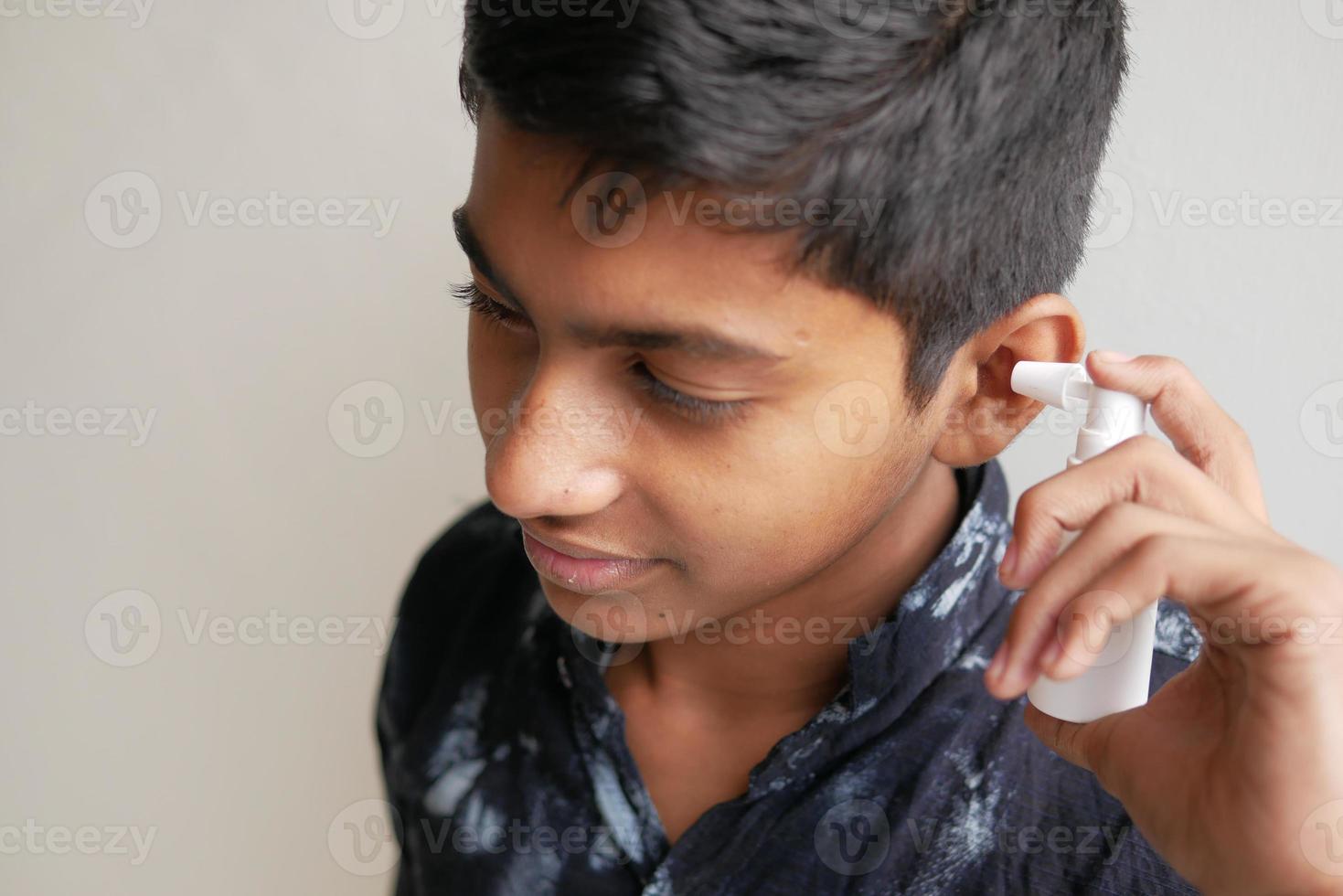 Close up of men using spray to remove earwax photo