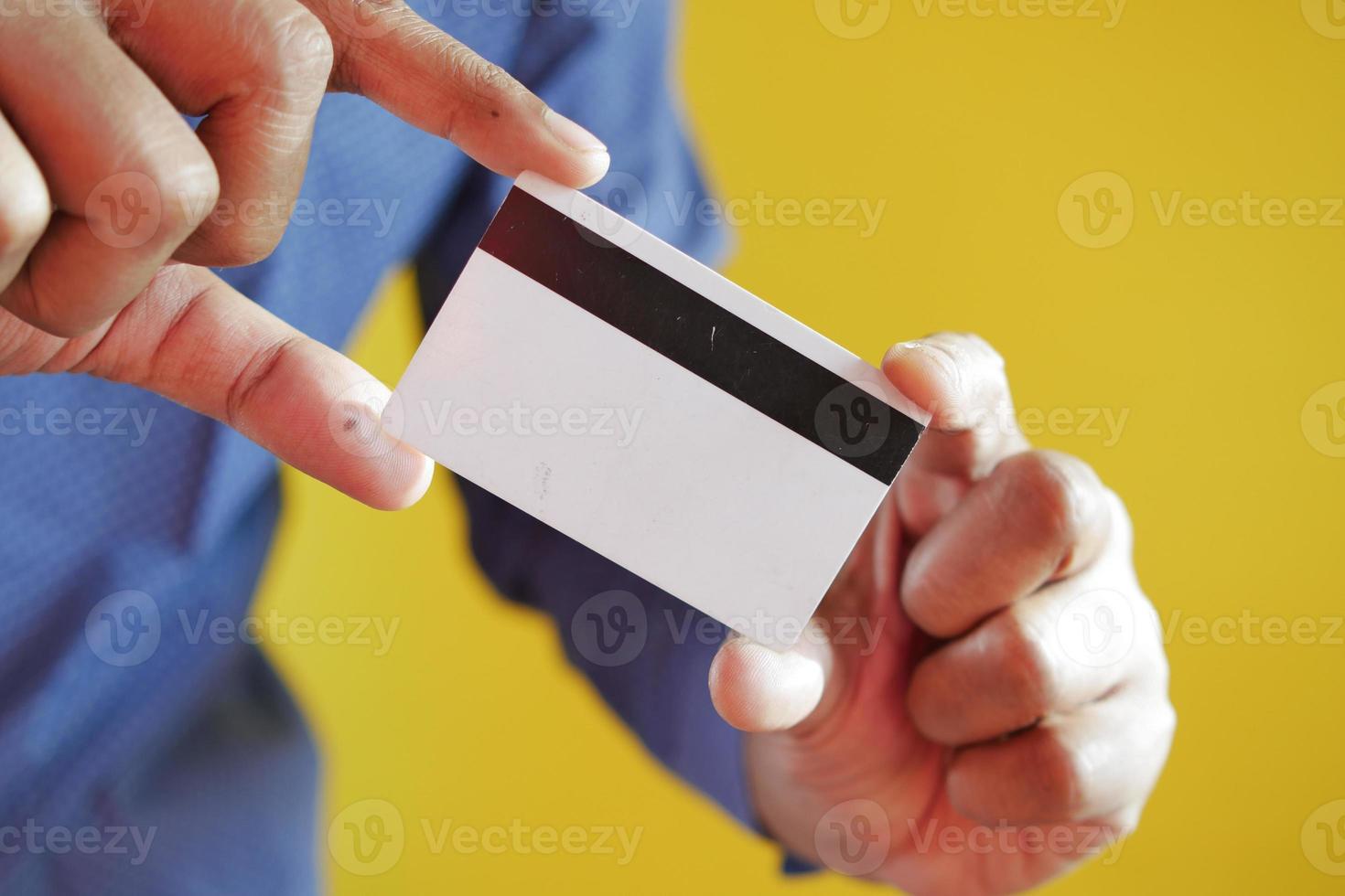 Man in casual dress showing credit card photo