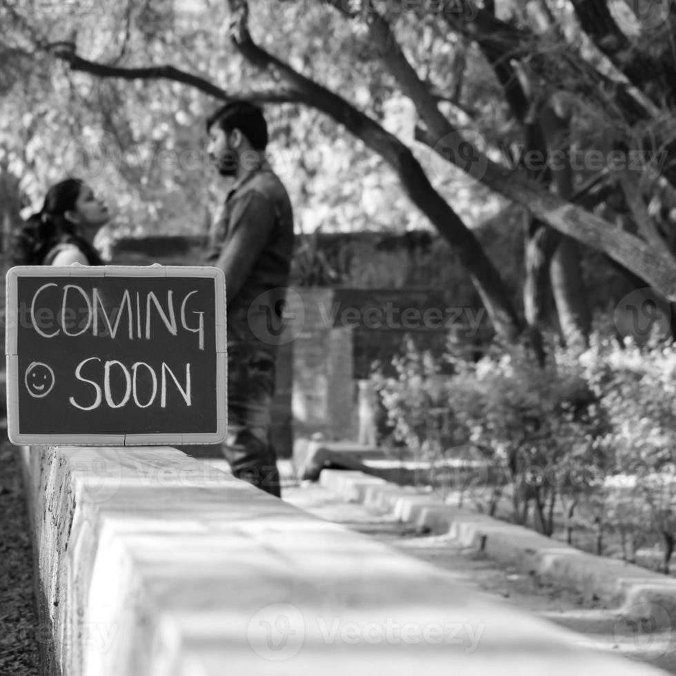 pareja india posando para una sesión de fotos de maternidad. la pareja está posando en un césped con hierba verde y la mujer está faluntando su panza en el jardín lodhi en nueva delhi, india