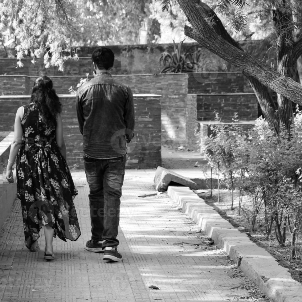 pareja india posando para una sesión de fotos de maternidad. la pareja está posando en un césped con hierba verde y la mujer está faluntando su panza en el jardín lodhi en nueva delhi, india