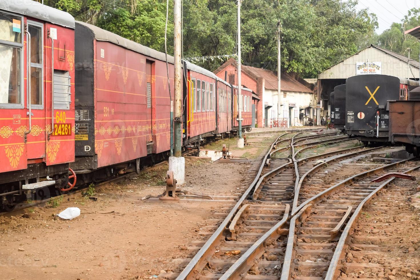 vista del vagón de tren de juguete desde el medio de la vía férrea durante el día cerca de la estación de tren de kalka en india, vista del vagón de tren de juguete, unión ferroviaria india, industria pesada foto