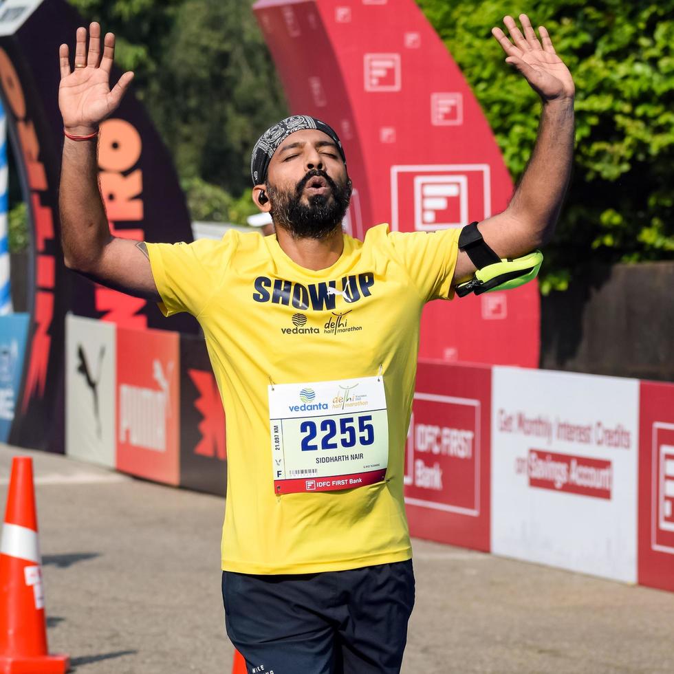 New Delhi, India - October 16 2022 - Vedanta Delhi Half Marathon race after covid in which marathon participants about to cross the finish line, Delhi Half Marathon 2022 photo