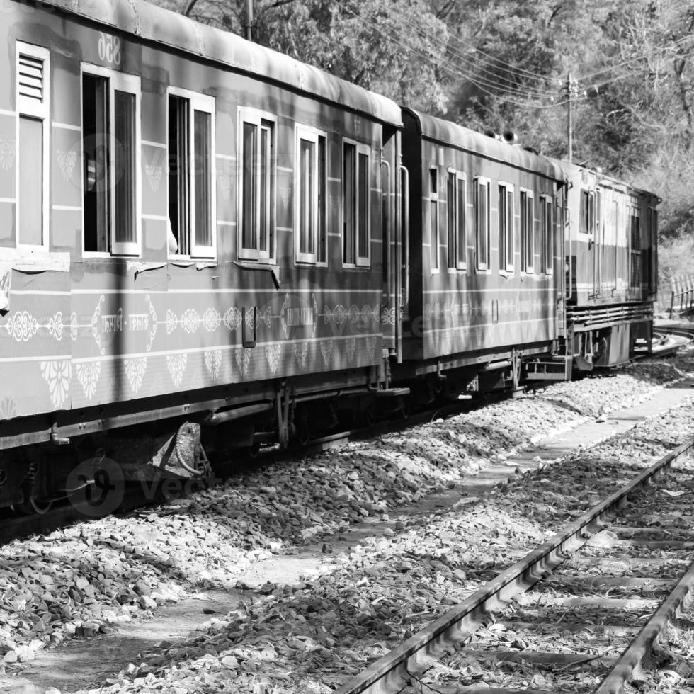 Toy Train moving on mountain slope, beautiful view, one side mountain, one side valley moving on railway to the hill, among green natural forest. Toy train from Kalka to Shimla in India photo