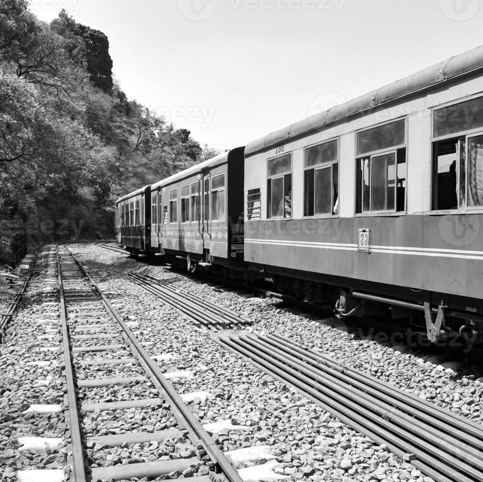 tren de juguete moviéndose en la ladera de la montaña, hermosa vista, una montaña lateral, un valle lateral moviéndose en ferrocarril hacia la colina, entre bosques naturales verdes. tren de juguete de kalka a shimla en india foto