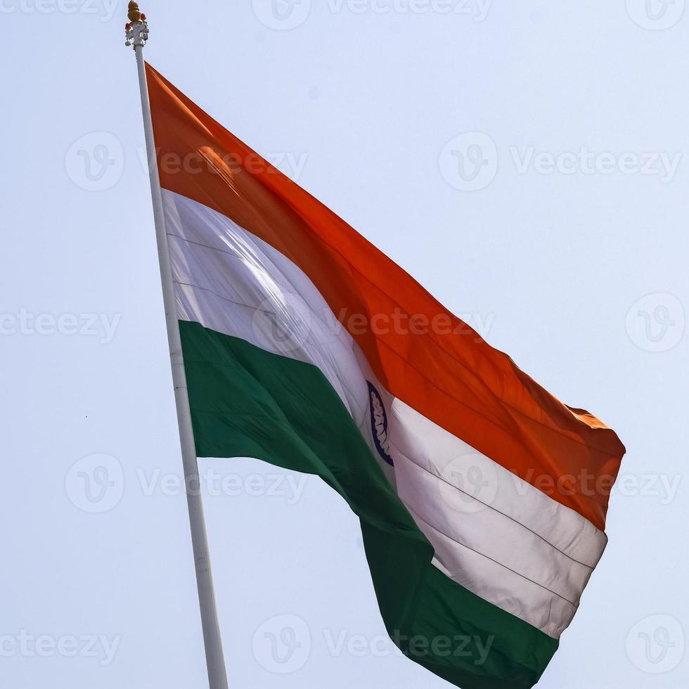 India flag flying high at Connaught Place with pride in blue sky, India flag fluttering, Indian Flag on Independence Day and Republic Day of India, tilt up shot, Waving Indian flag, Har Ghar Tiranga photo