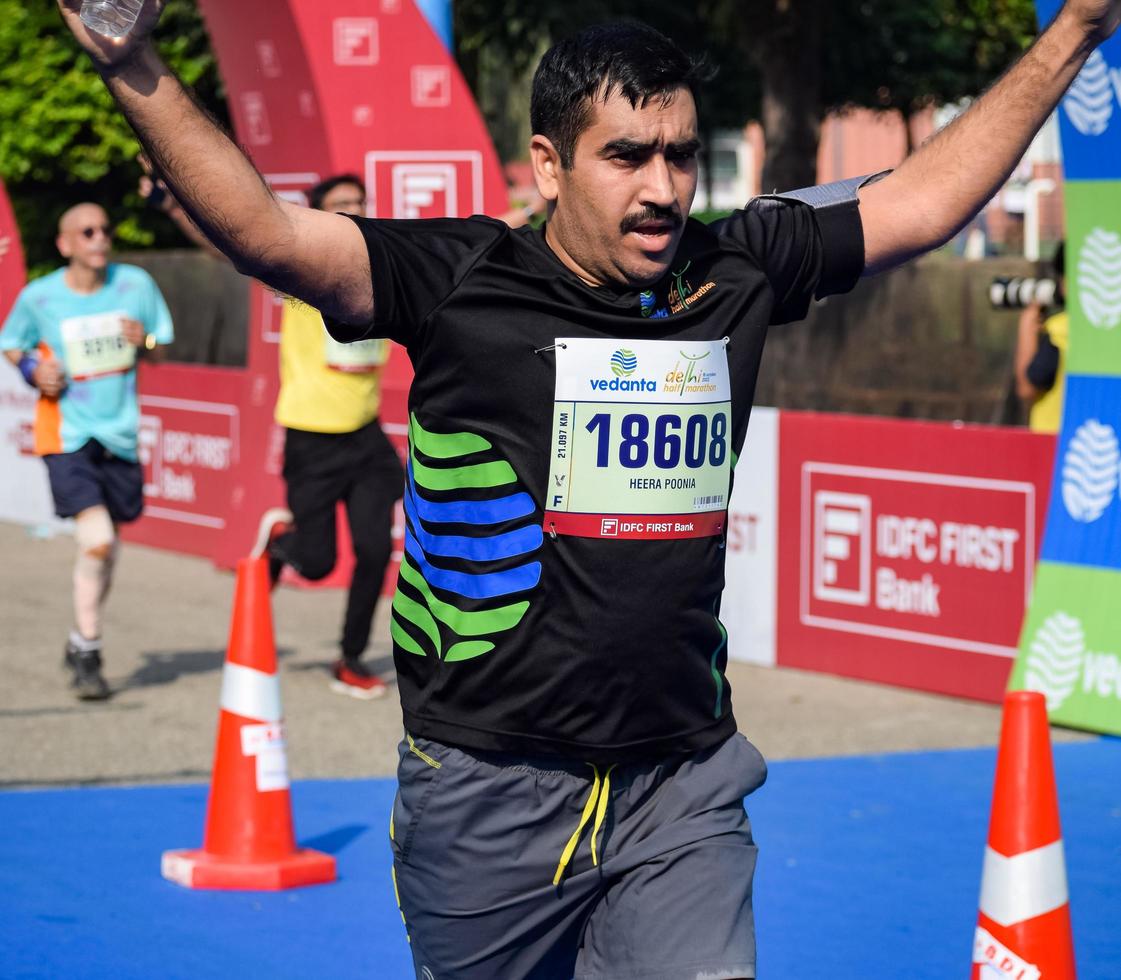 New Delhi, India - October 16 2022 - Vedanta Delhi Half Marathon race after covid in which marathon participants about to cross the finish line, Delhi Half Marathon 2022 photo