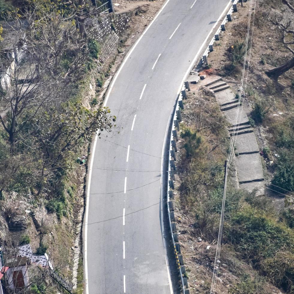 Aerial top view of traffic vehicles driving at mountains roads at Nainital, Uttarakhand, India, View from the top side of mountain for movement of traffic vehicles photo