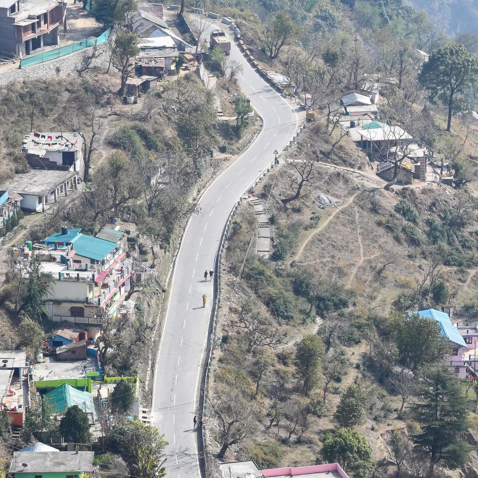 Aerial top view of traffic vehicles driving at mountains roads at Nainital, Uttarakhand, India, View from the top side of mountain for movement of traffic vehicles photo