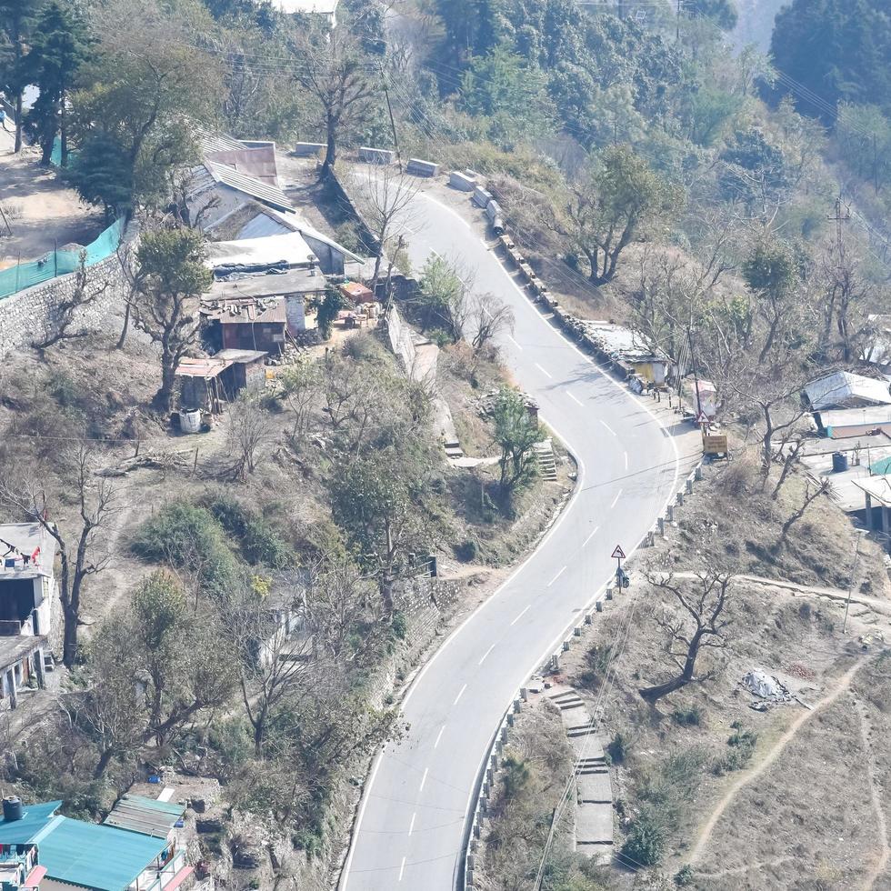 Aerial top view of traffic vehicles driving at mountains roads at Nainital, Uttarakhand, India, View from the top side of mountain for movement of traffic vehicles photo