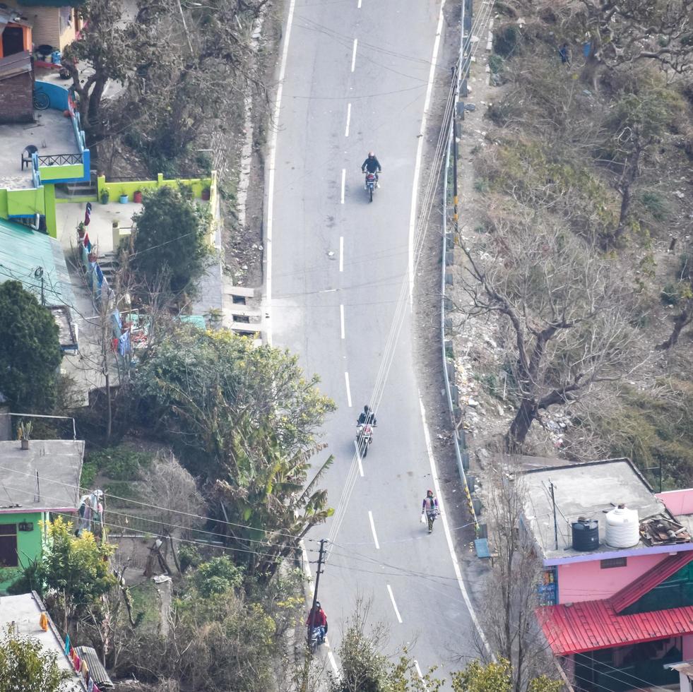 Aerial top view of traffic vehicles driving at mountains roads at Nainital, Uttarakhand, India, View from the top side of mountain for movement of traffic vehicles photo