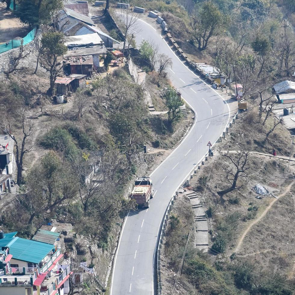 Aerial top view of traffic vehicles driving at mountains roads at Nainital, Uttarakhand, India, View from the top side of mountain for movement of traffic vehicles photo