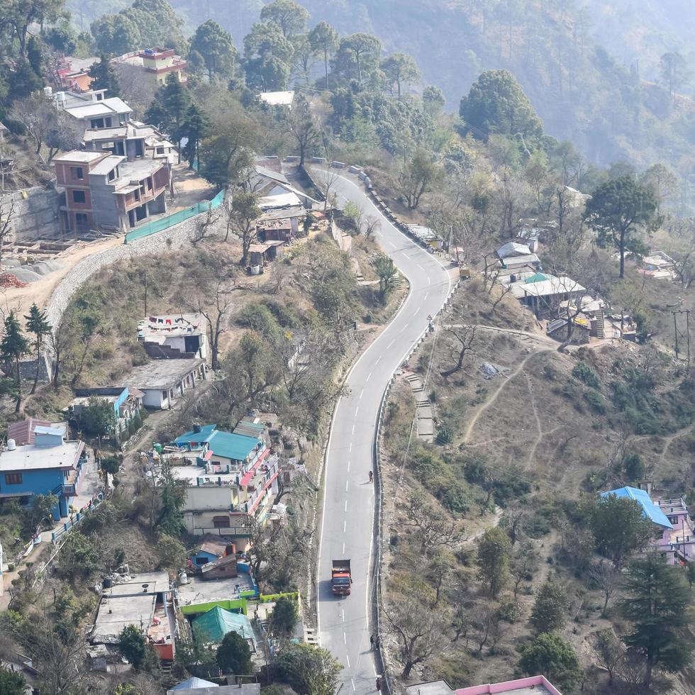 Aerial top view of traffic vehicles driving at mountains roads at Nainital, Uttarakhand, India, View from the top side of mountain for movement of traffic vehicles photo