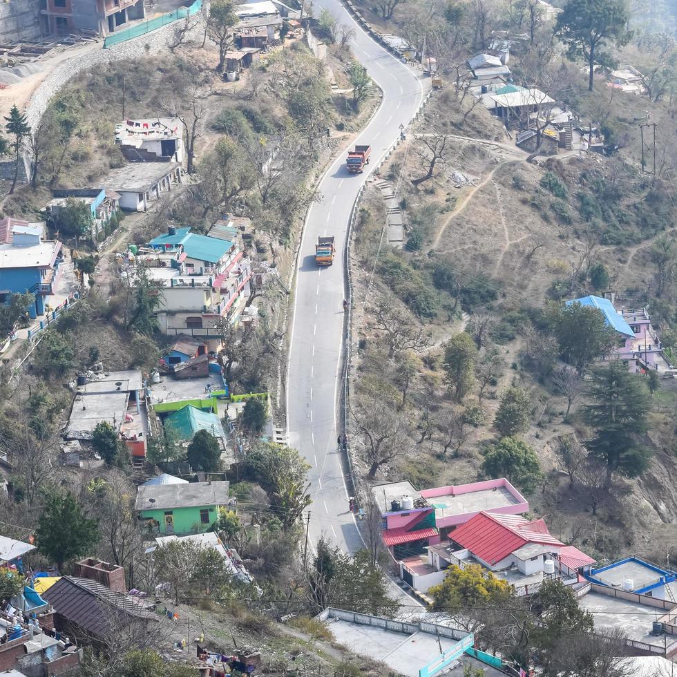 Aerial top view of traffic vehicles driving at mountains roads at Nainital, Uttarakhand, India, View from the top side of mountain for movement of traffic vehicles photo