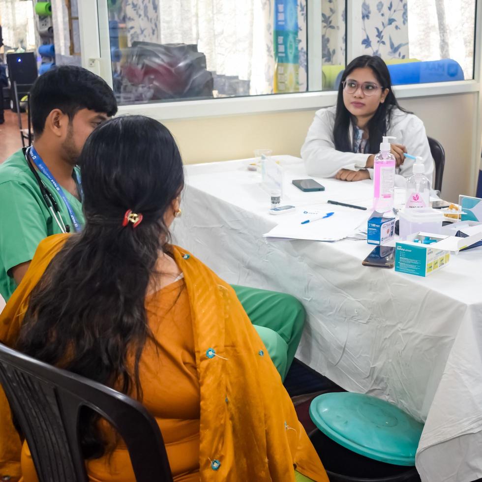 Delhi, India - November 19, 2022 - Basic routine health check-up camp has been organized by max hospital specialized doctors, Patient at annual health check-up, Doctor doing health check-up to patient photo