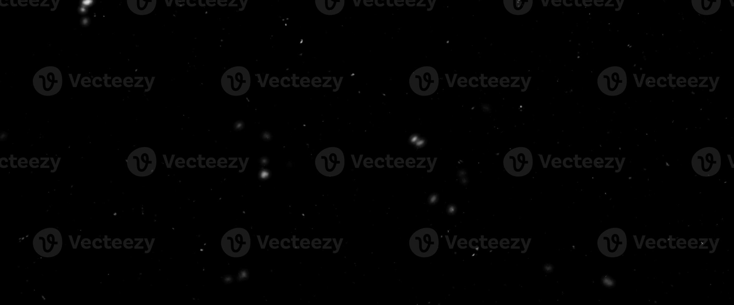 Snowfall bokeh on black background. Many snowflakes in flying in the air. Winte night snowfall and blizzard of snow at. Blur bokeh light effect creative background. photo